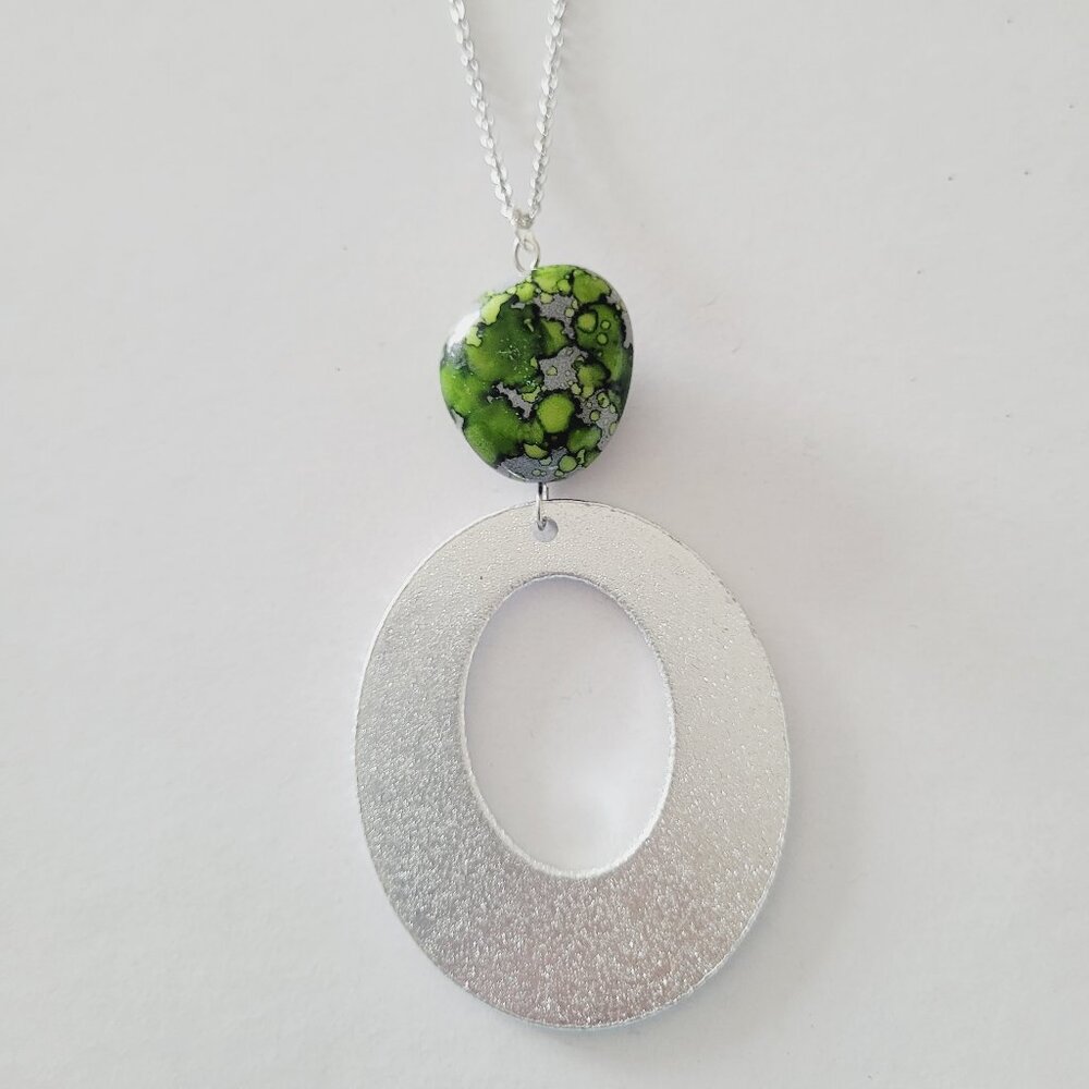 Cadena en steel plateada con pendan en aluminio y piedra verde, negro y gris